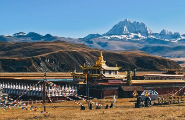 Tibetan-holy-mountain-Mt.-Yala-with-its-summit-at-5820m-and-Tagong-temple,-Sichuan,-China.