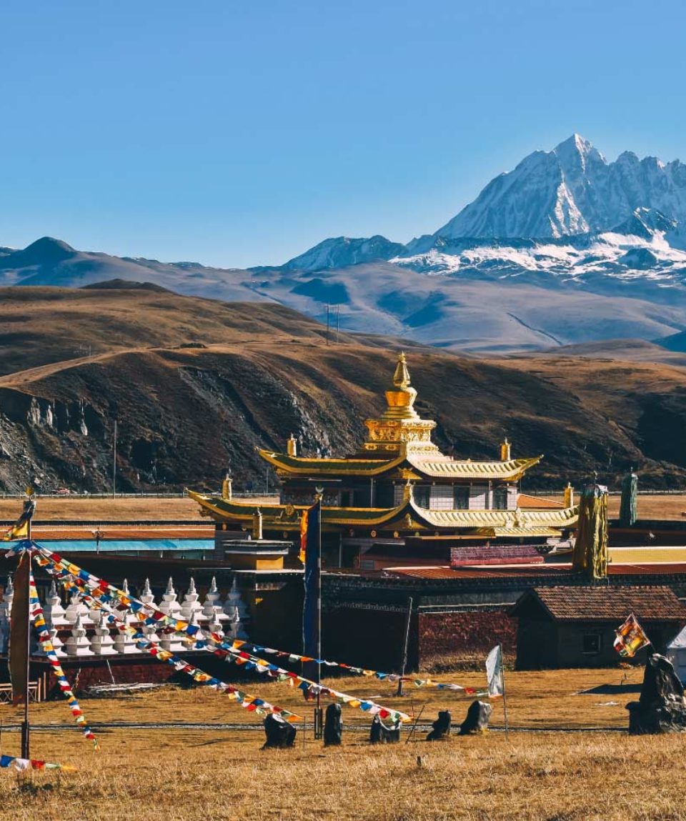 Tibetan-holy-mountain-Mt.-Yala-with-its-summit-at-5820m-and-Tagong-temple,-Sichuan,-China.